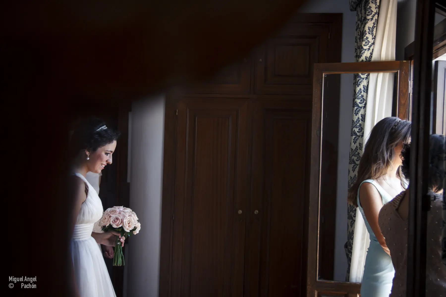 Novia junto a una ventana durante los preparativos