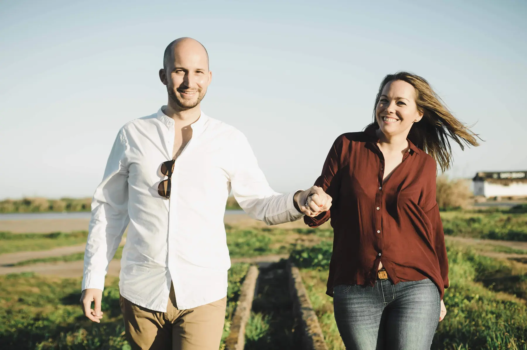 Pareja caminando de la mano por el campo