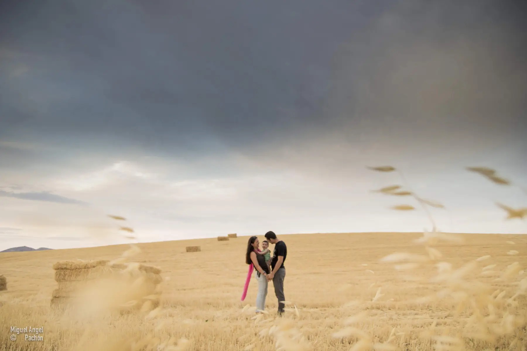 Pareja entre dunas bajo un cielo nublado
