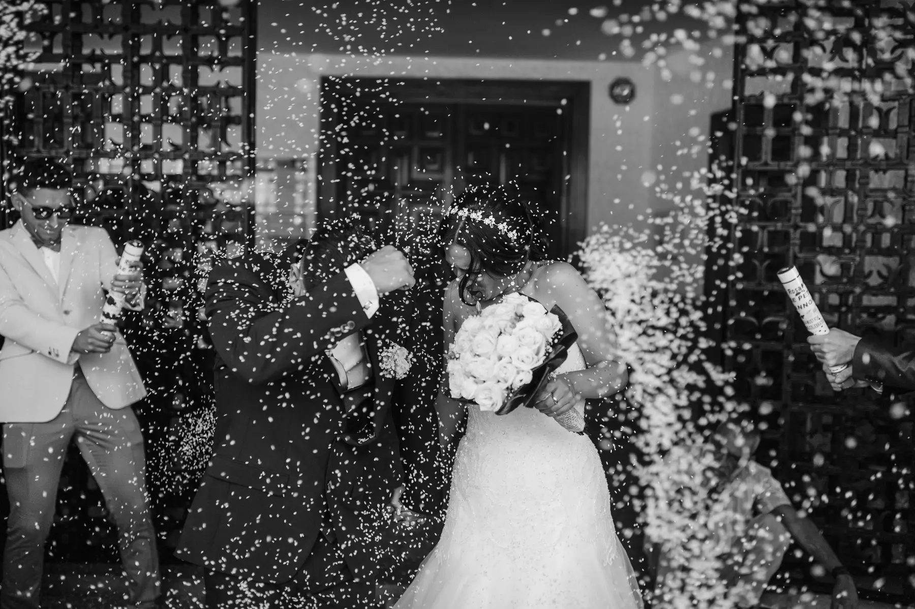 Novios besándose entre el confeti de sus invitados