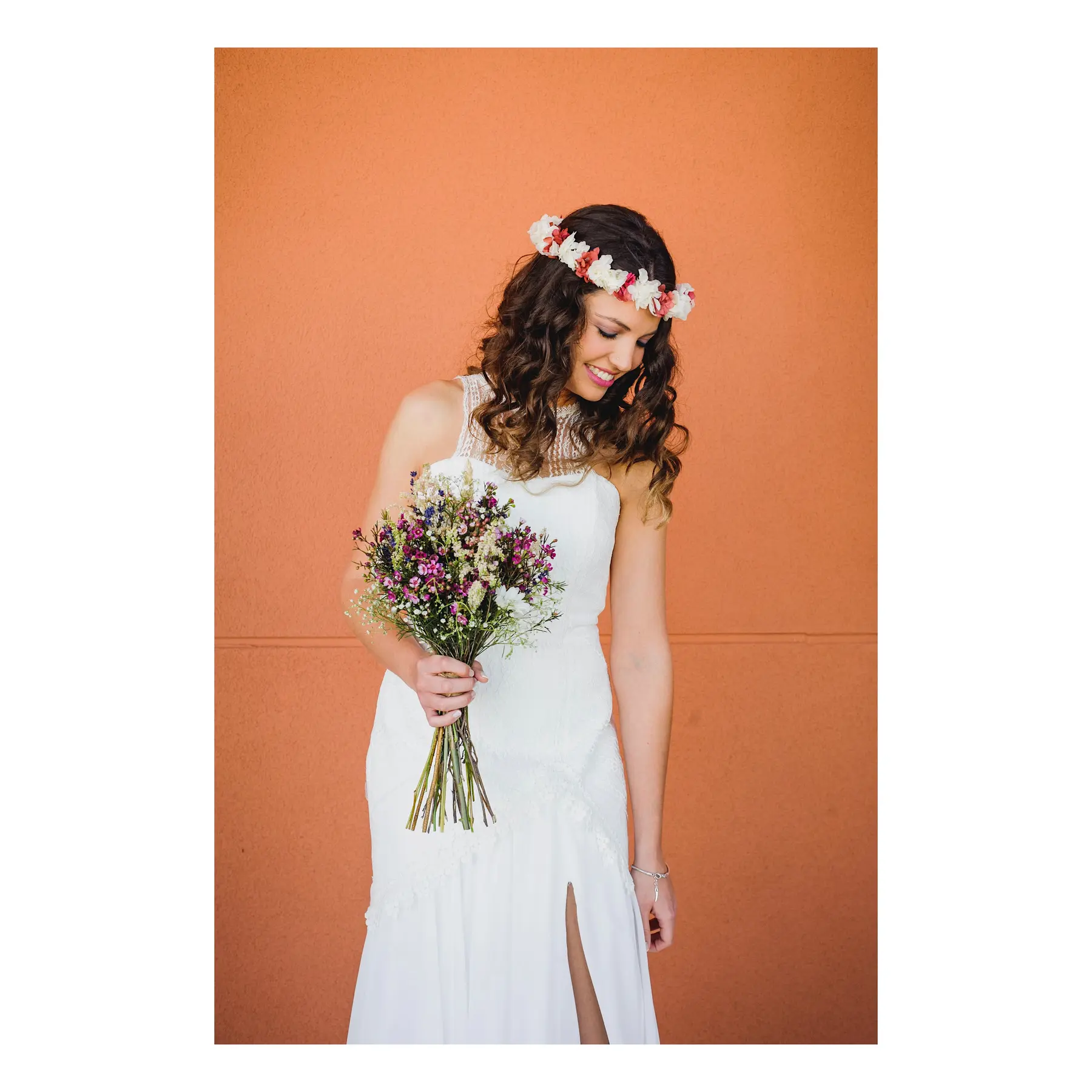 Novia con ramo y corona de flores sobre fondo naranja