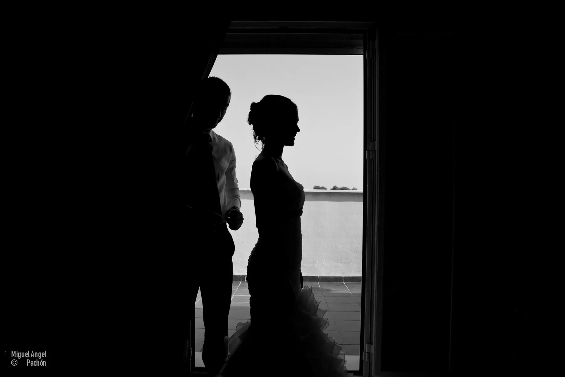 Pareja en silueta junto a una ventana