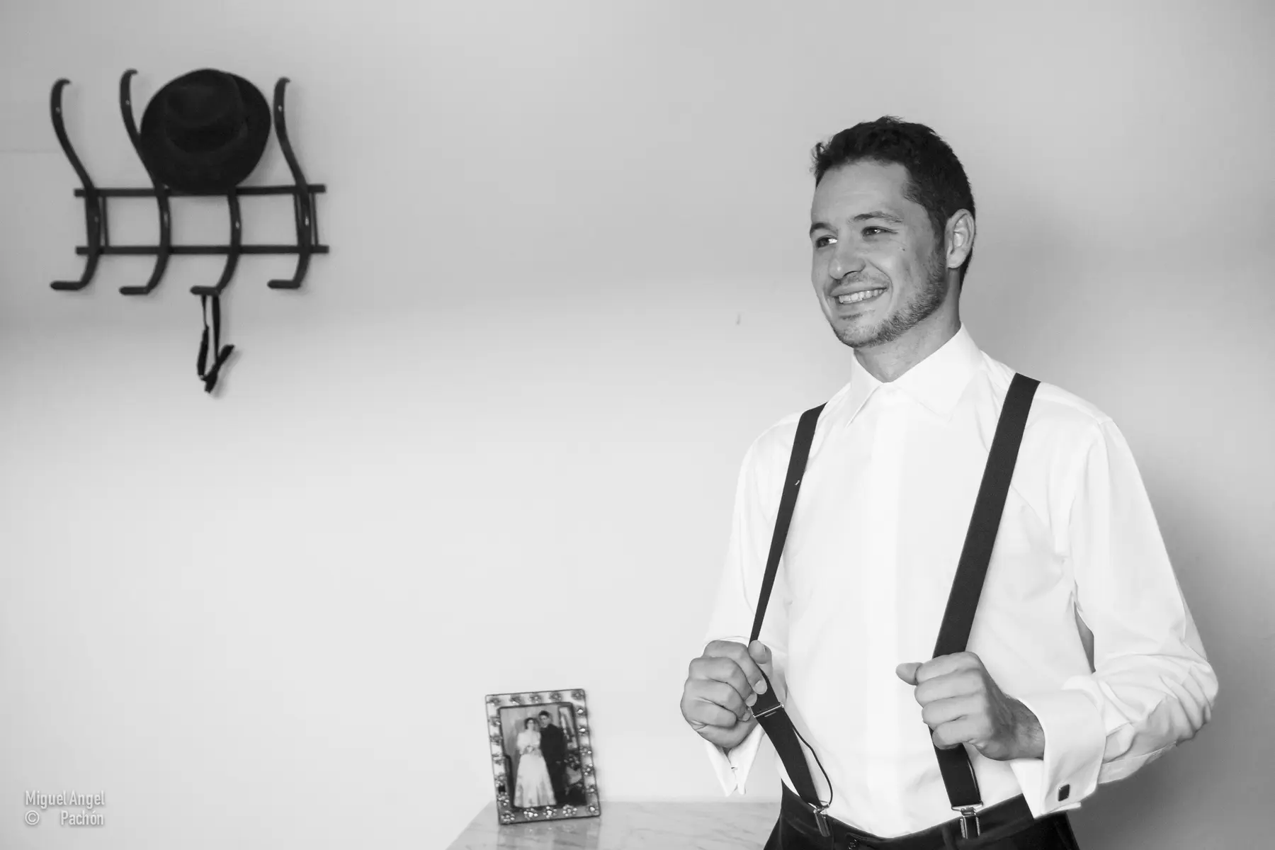 Novio sonriente con tirantes en blanco y negro