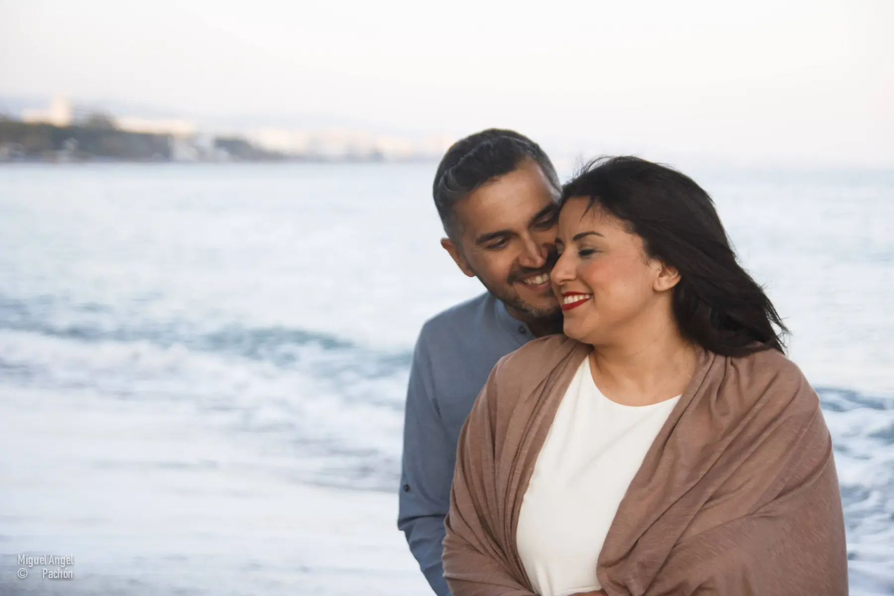 Pareja abrazada junto al mar