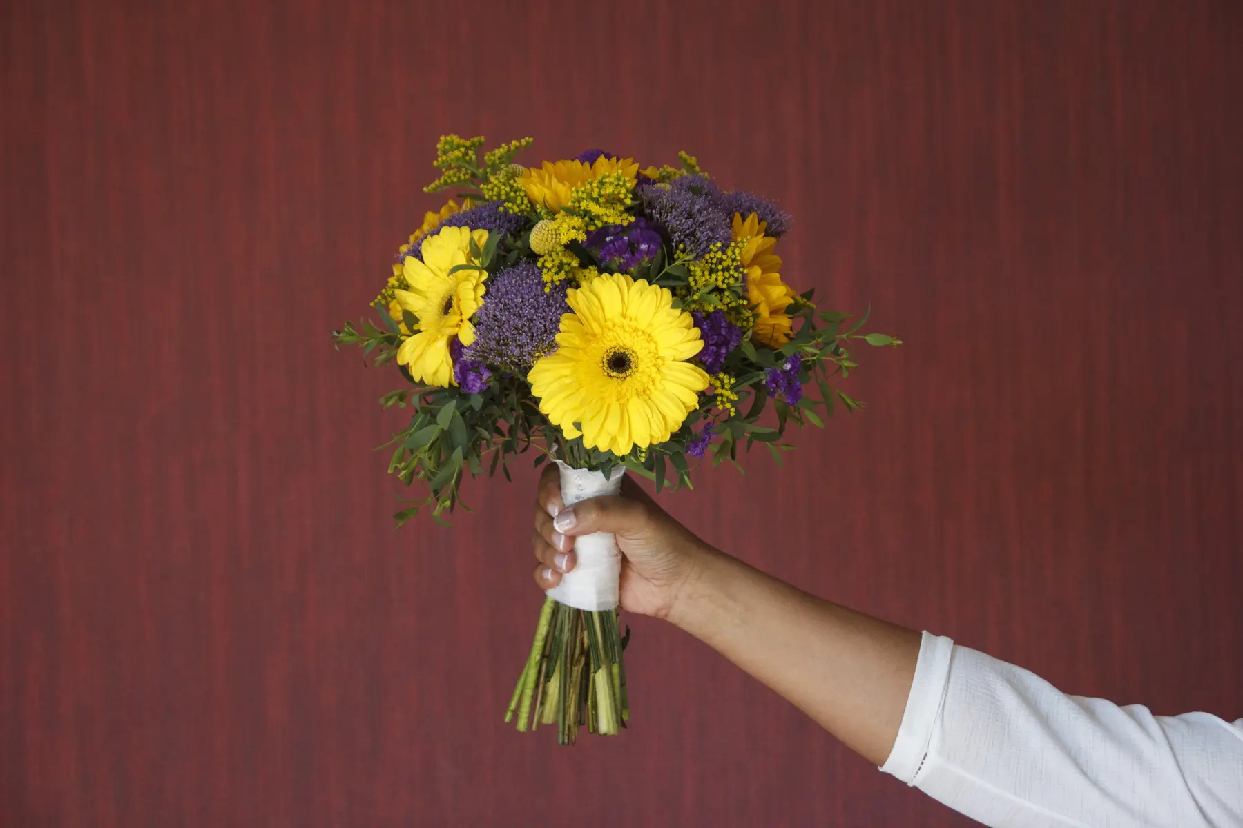 Ramo de flores amarillas sostenido por la novia