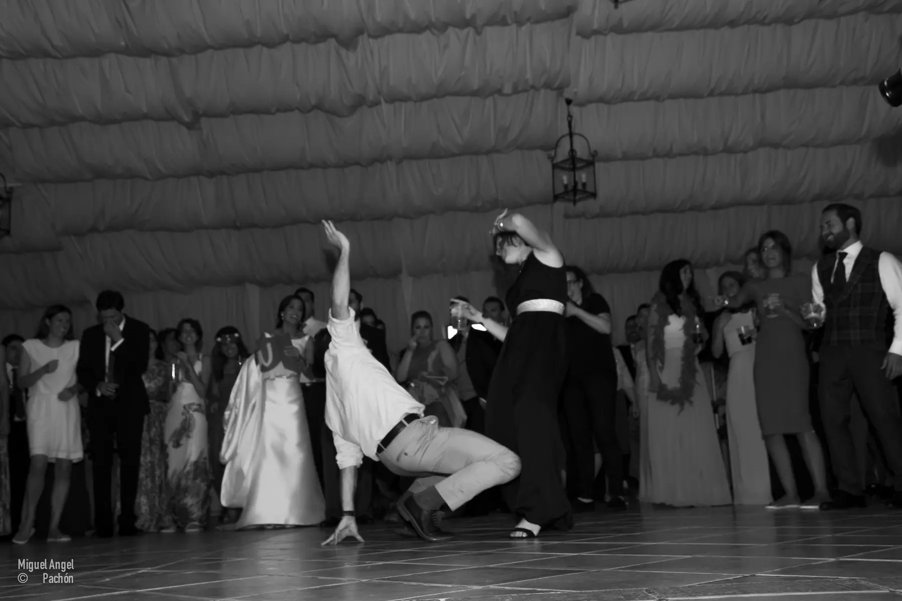 Novios bailando ante sus invitados en blanco y negro