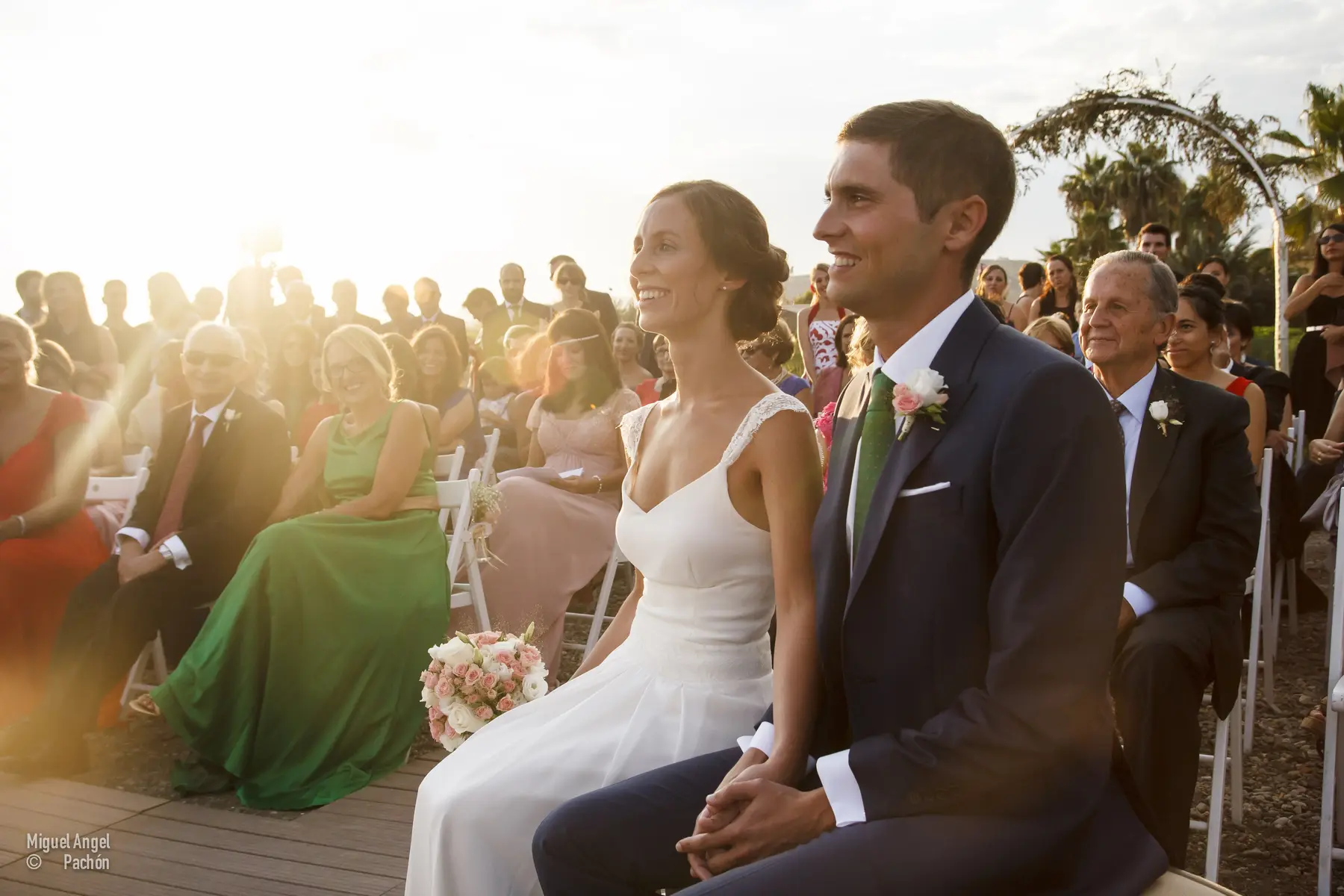 Novios sonrientes durante la ceremonia al aire libre
