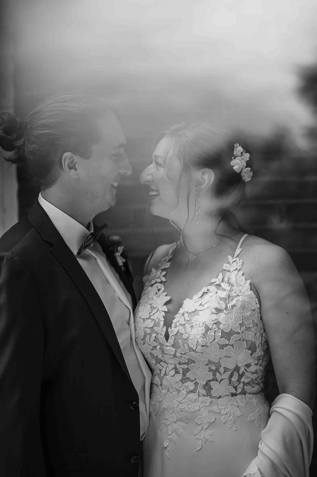 Novios besándose entre reflejos en blanco y negro