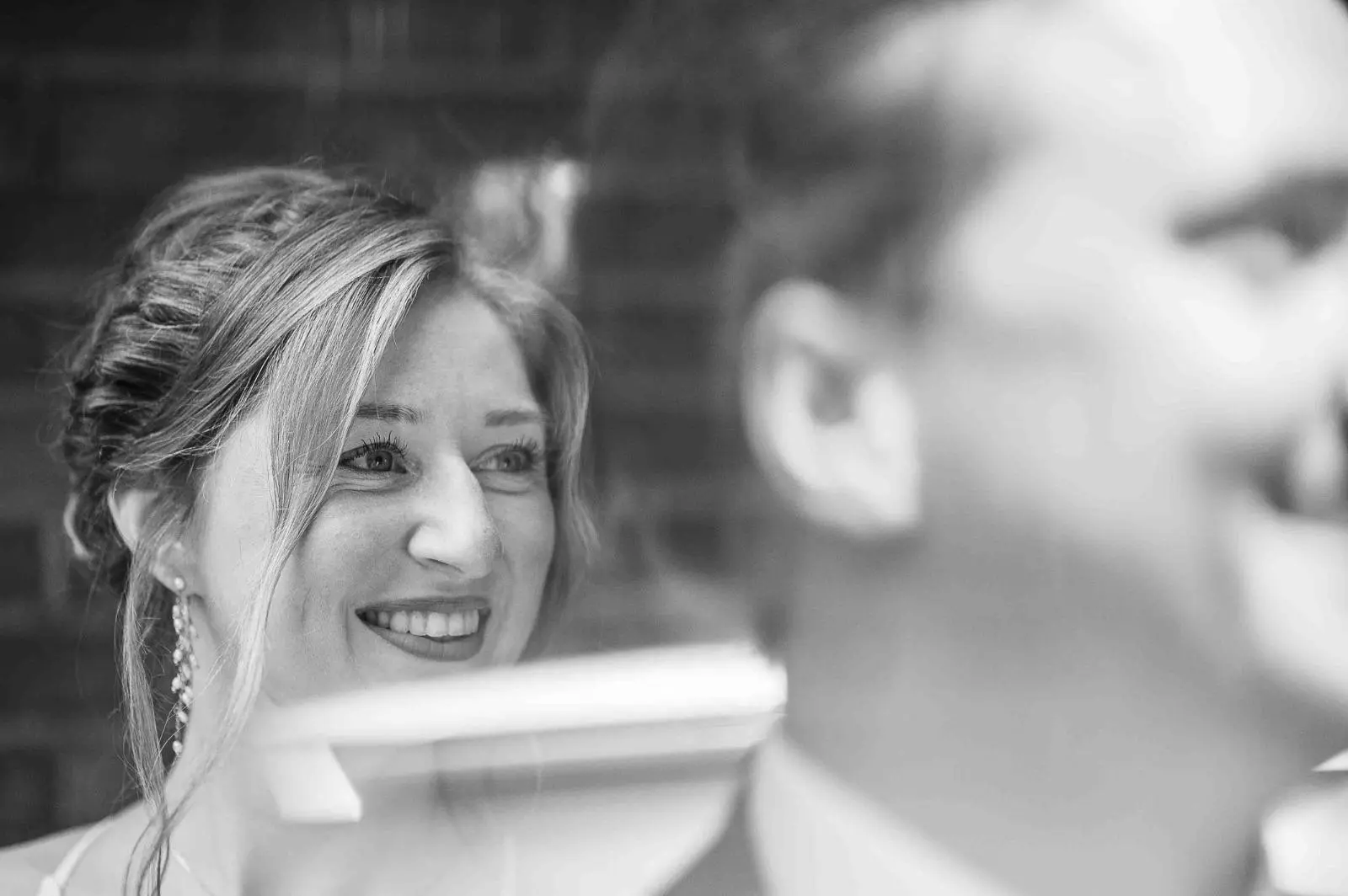 Sonrisa de la novia entre reflejos en blanco y negro
