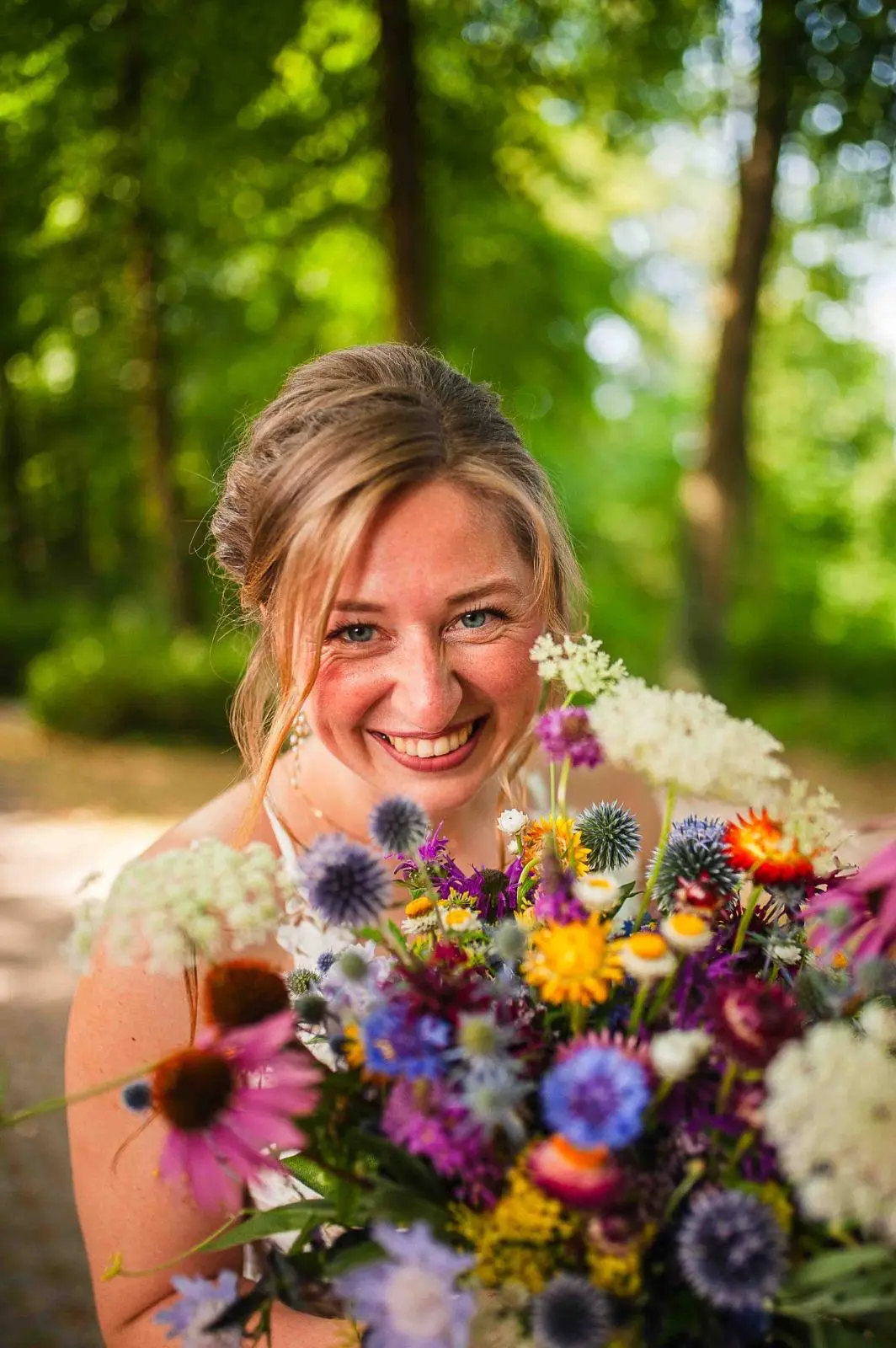 Novia sonriente con un ramo de flores de colores
