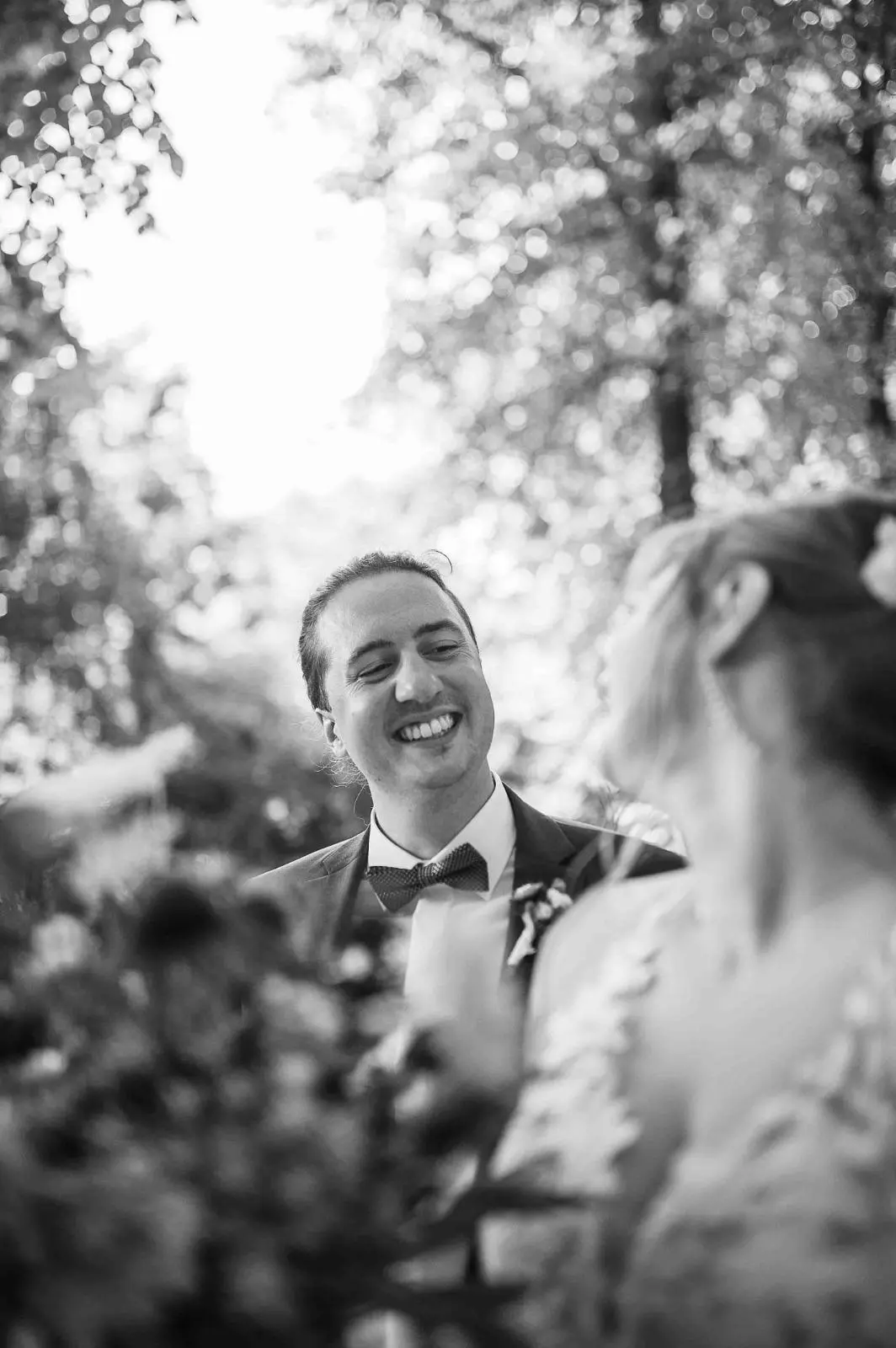 Novios entre hojas en blanco y negro