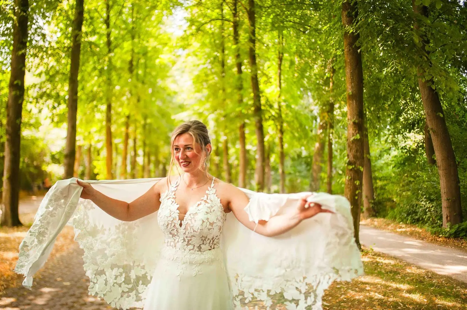 Novia sujetando el vestido entre árboles iluminados