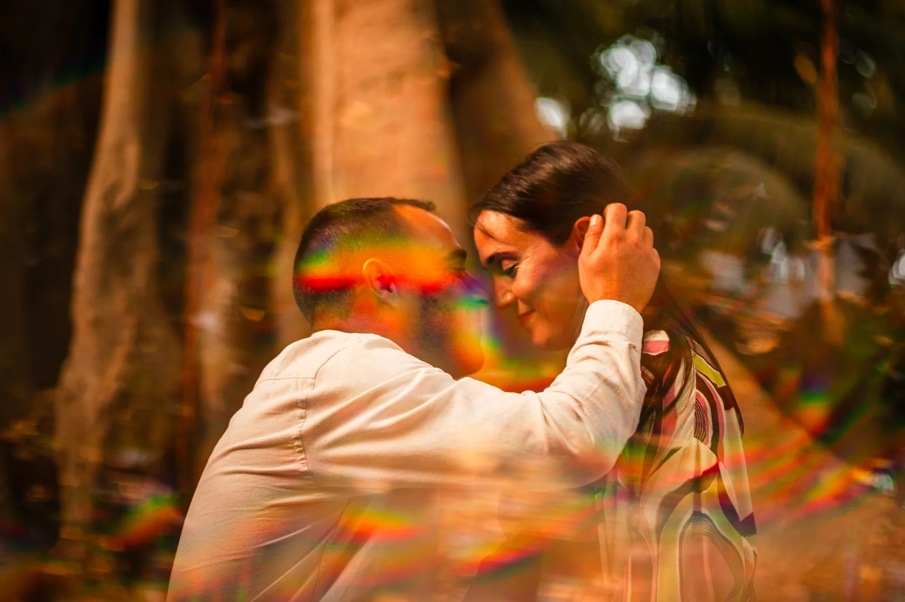 Beso de una pareja entre reflejos de color