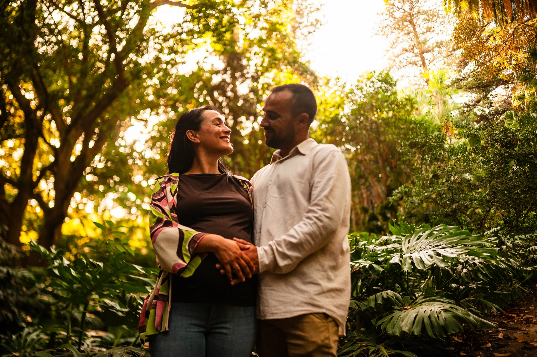 Pareja embarazada sonriente en un jardín