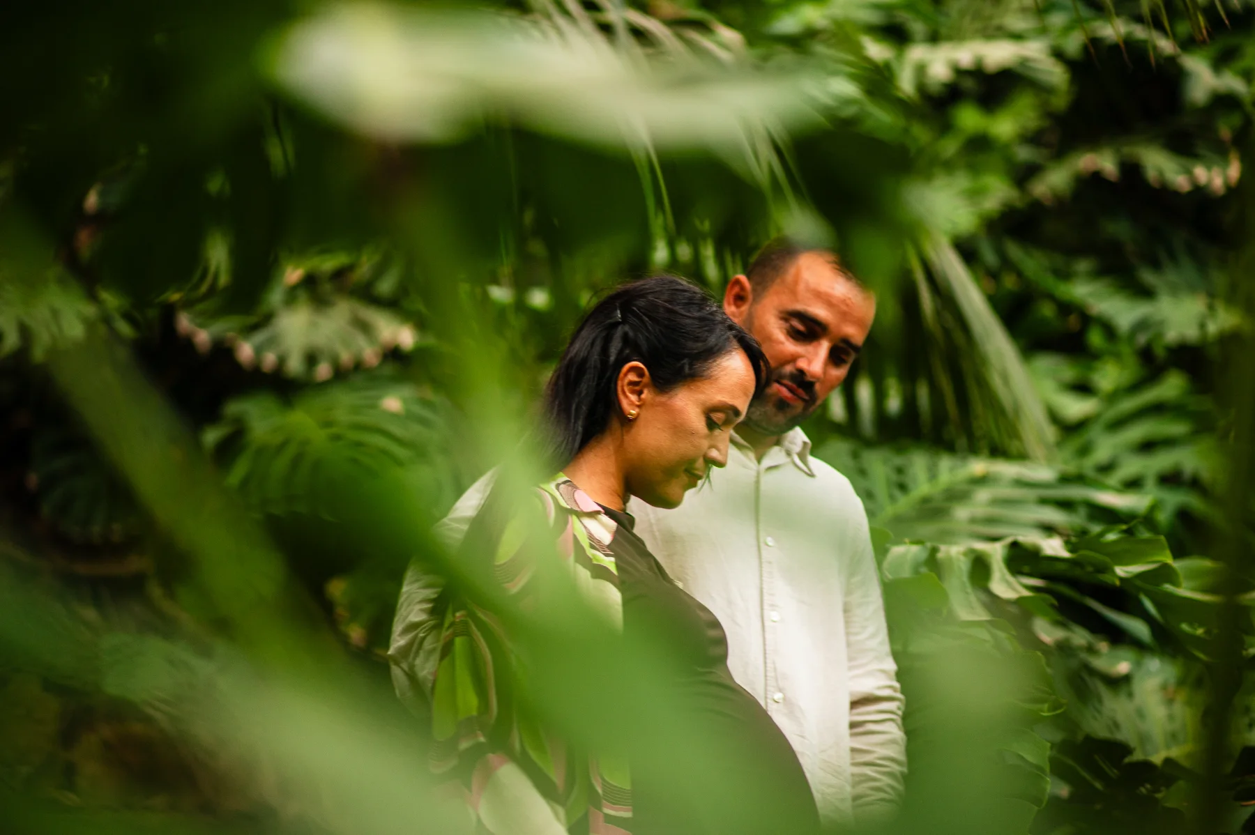 Pareja entre hojas verdes en primer plano