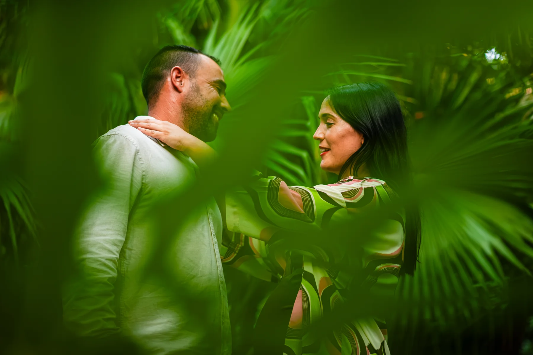Pareja embarazada conversando entre vegetación