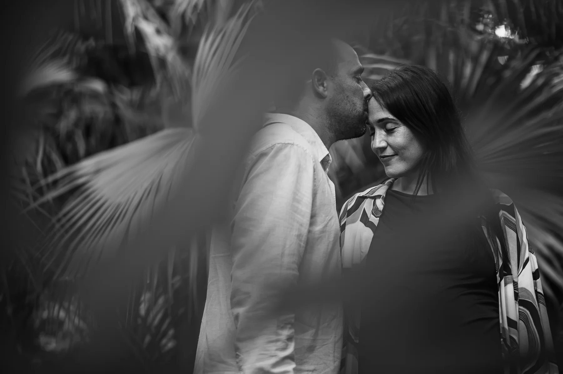 Miradas de una pareja entre hojas en blanco y negro