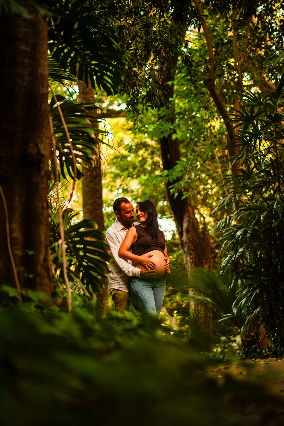 Abrazo de una pareja en un sendero rodeado de árboles