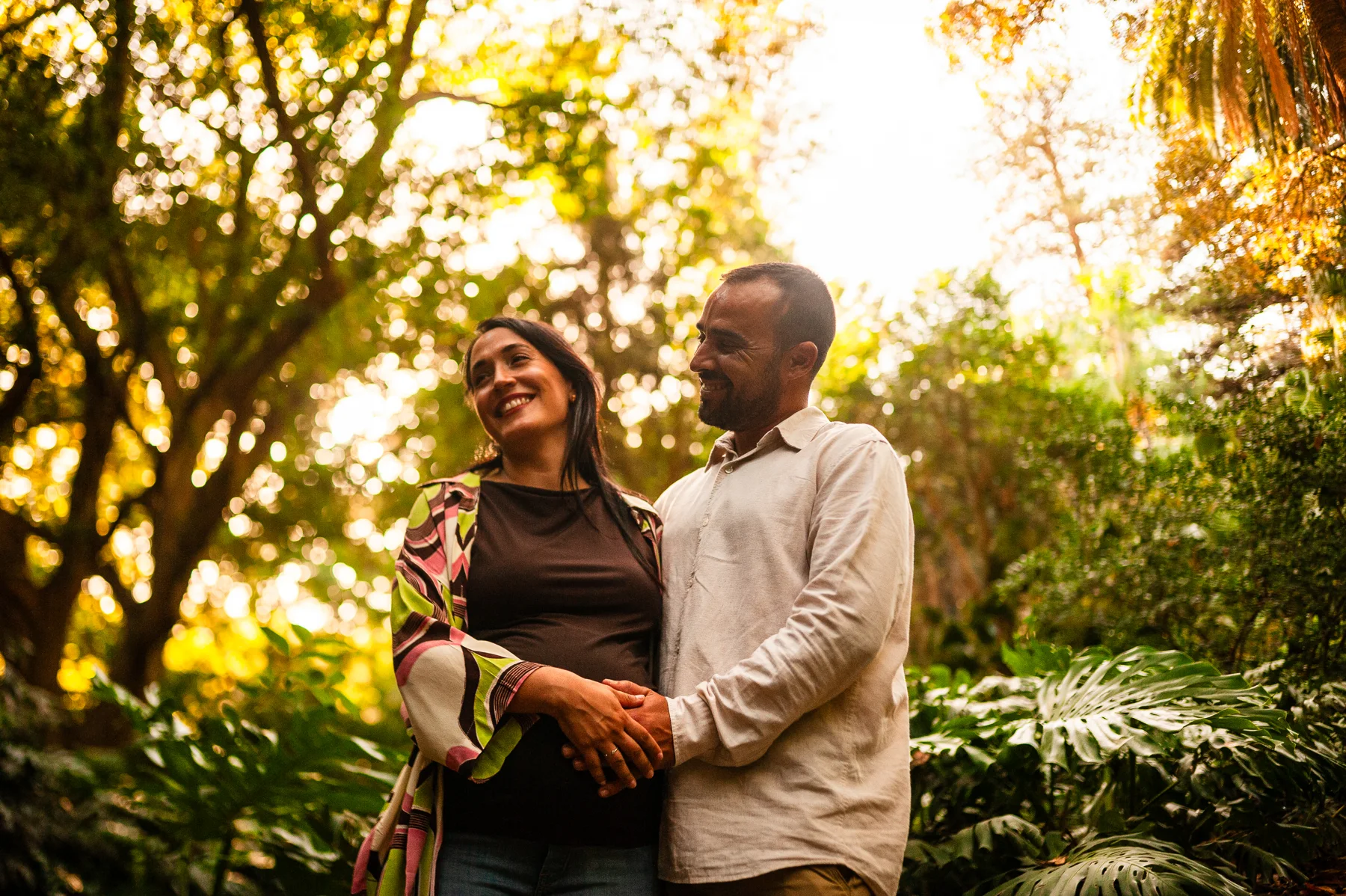 Pareja riendo a contraluz en el jardín