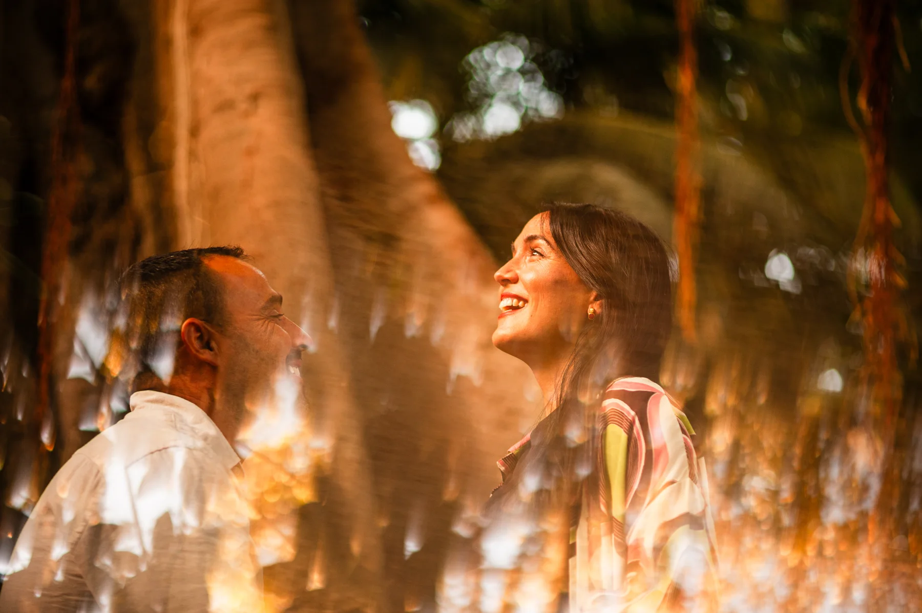 Pareja sonriente entre reflejos luminosos