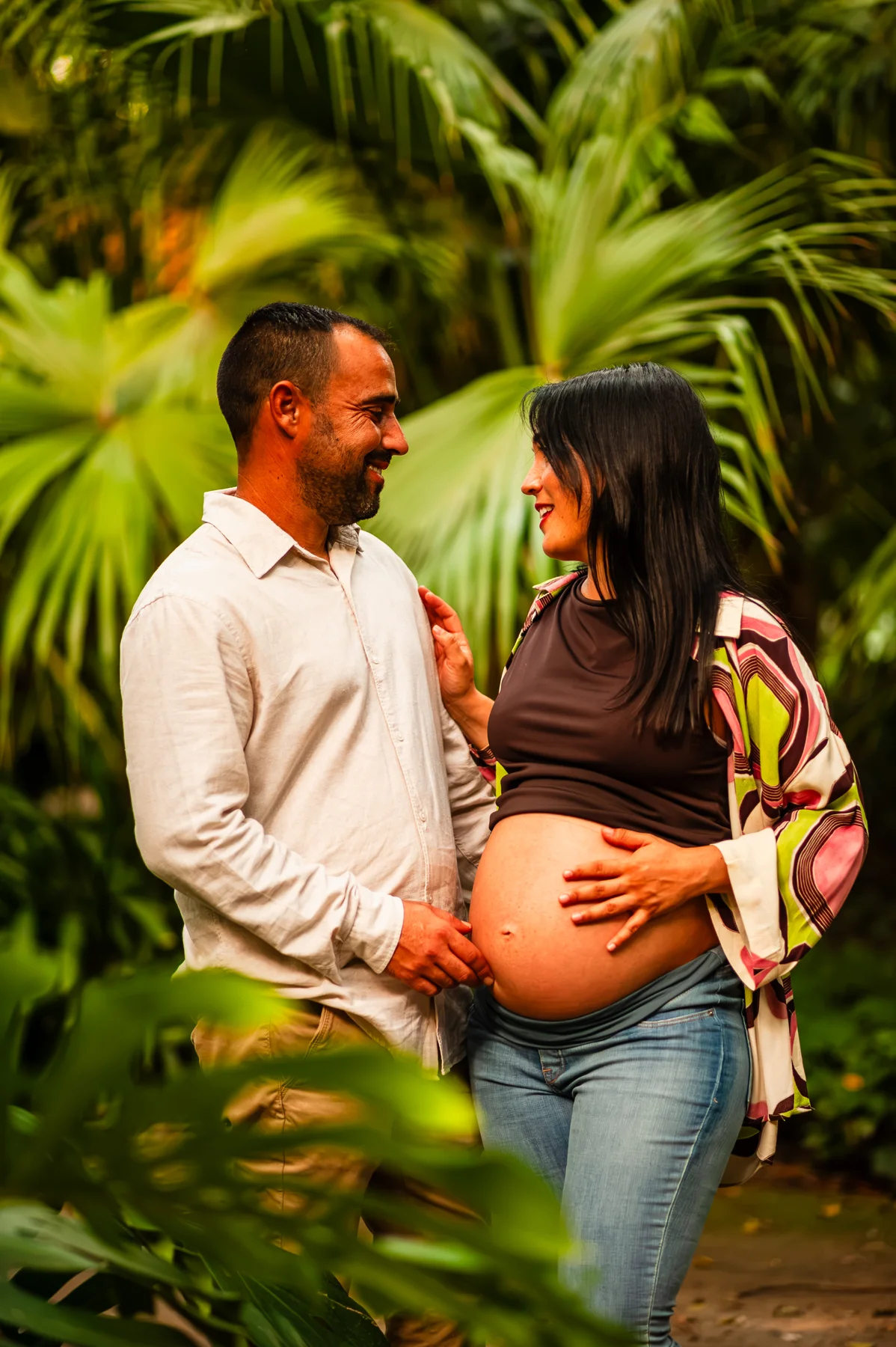 Pareja embarazada rodeada de vegetación