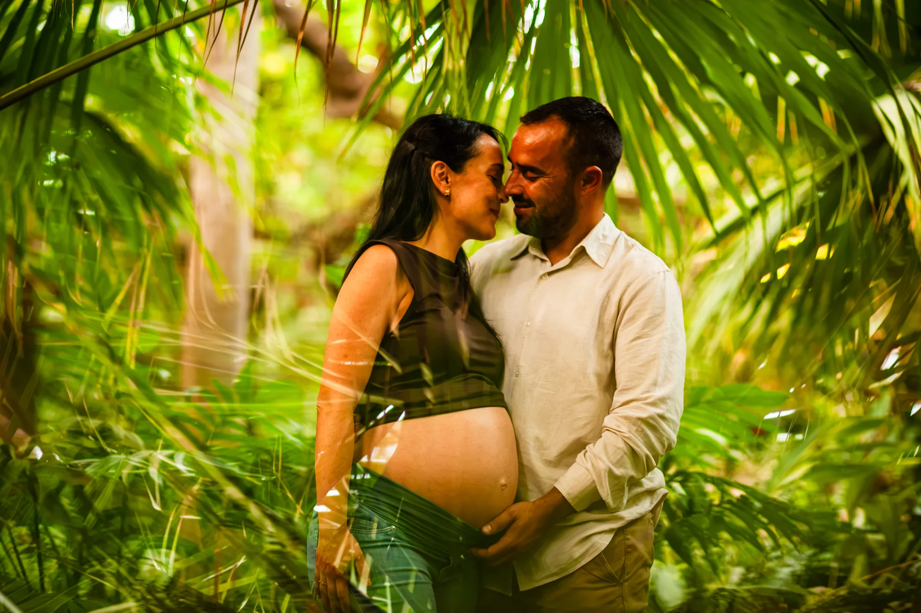 Pareja abrazada bajo palmeras con luz natural
