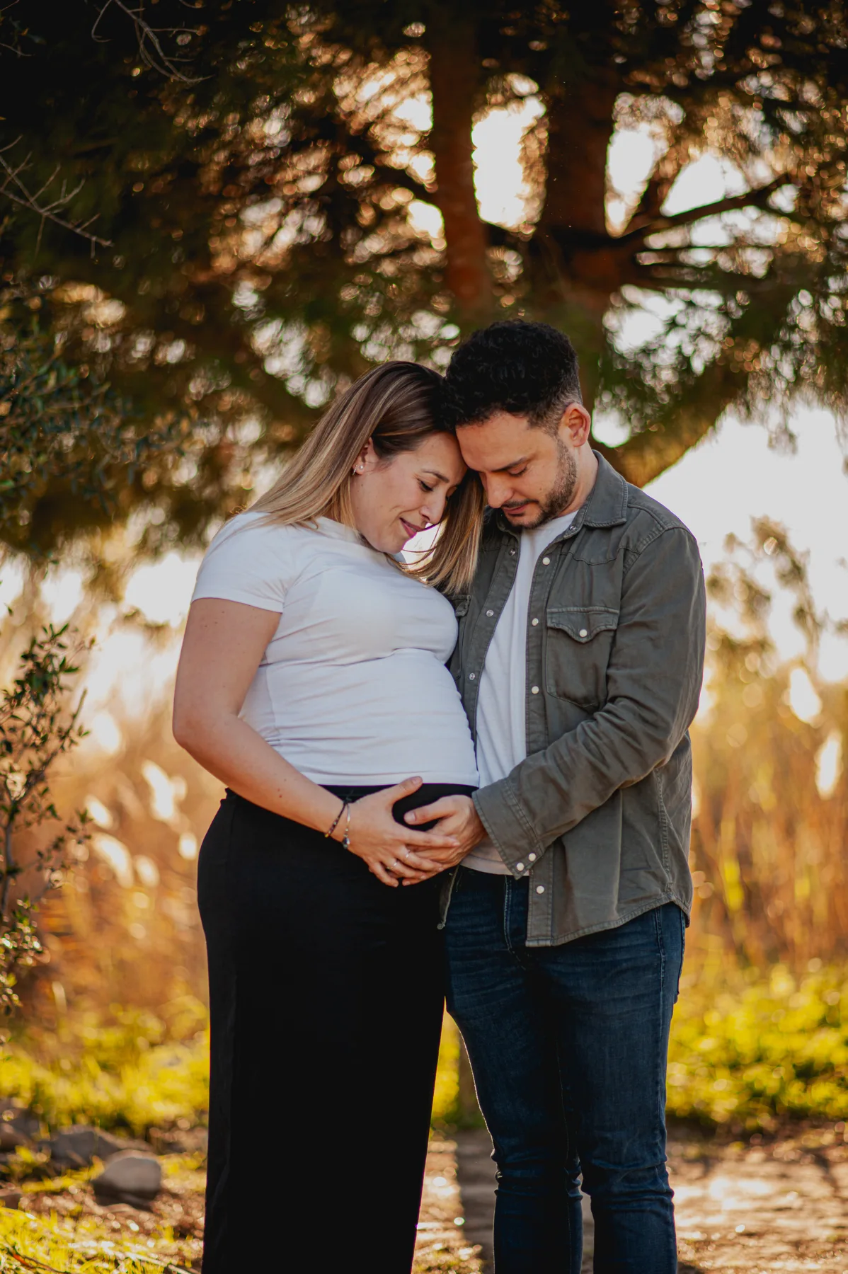 Pareja abrazada con las manos sobre el vientre