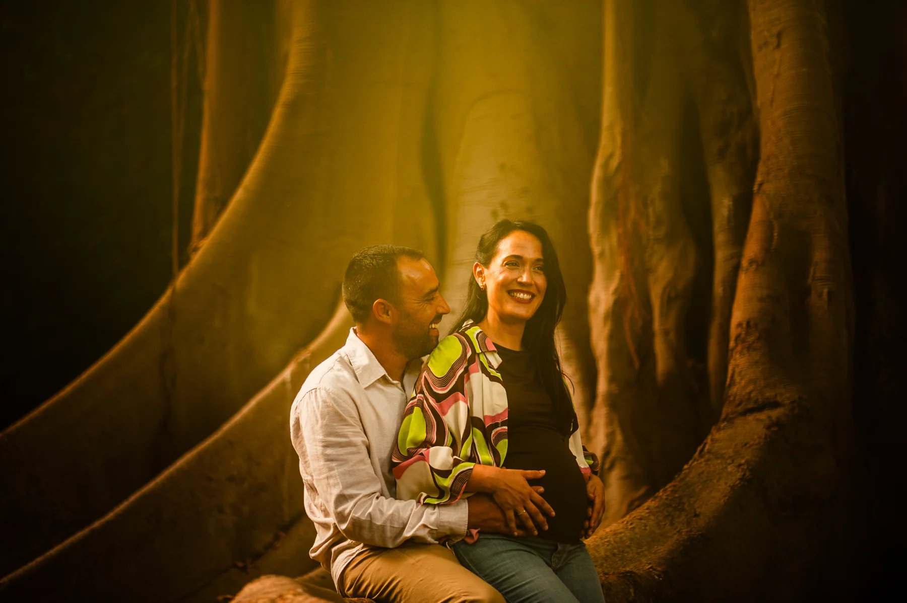 Pareja sentada entre las raíces de un árbol