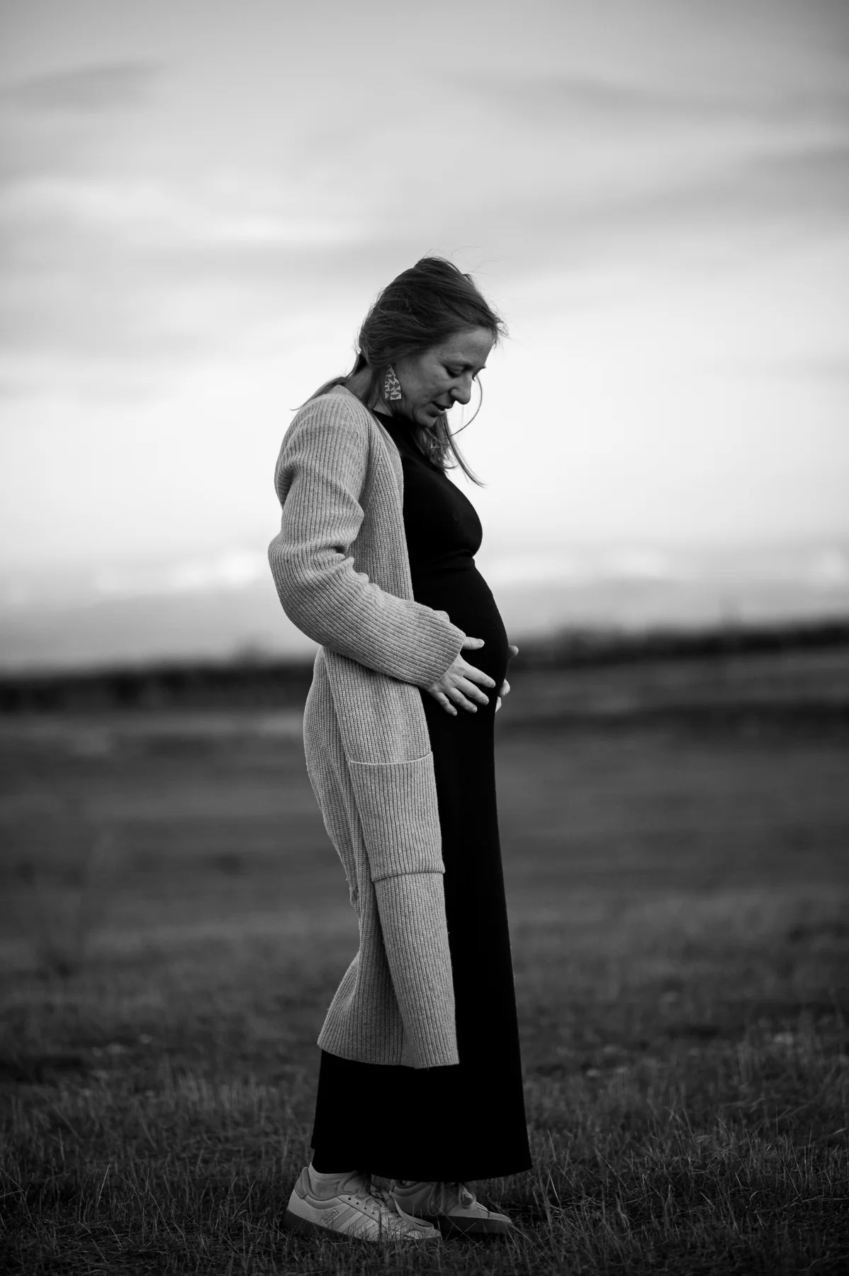 Mujer embarazada en un campo, en blanco y negro